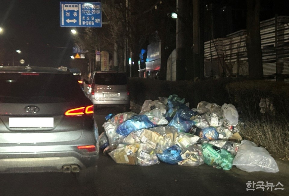 인천 남동구 예술로 320 앞 도로에 무단 투기된 쓰레기를 피해가는 차량. (사진=한국뉴스)