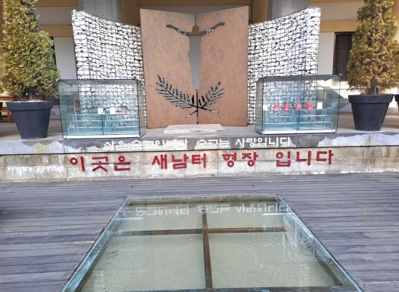 새남터순교성지 앞에 재현된 순교 당시의 형장과 유리속의 모래 모습(사진=김호선기자)